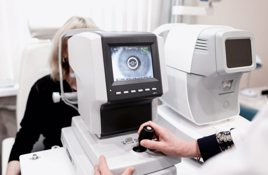 An optometrist using an auto refractor to capture retinal image of her patient's eyes.