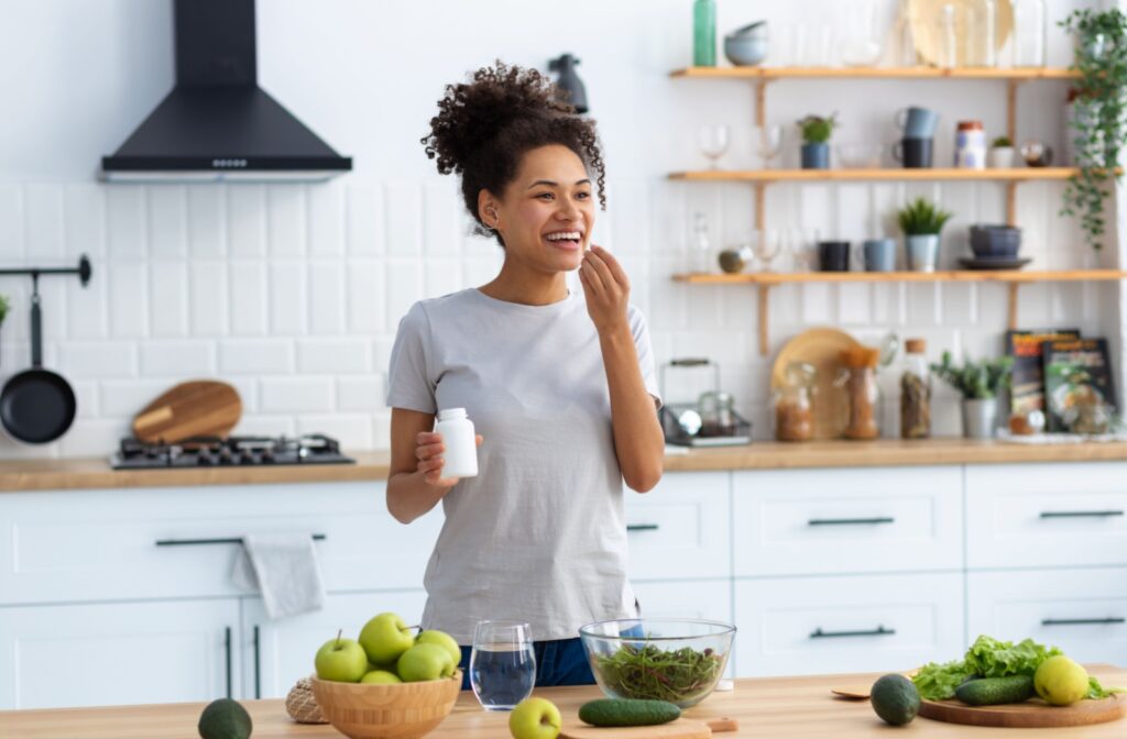 A young woman is happy in her kitchen, surrounded by healthy foods that help improve ocular health.